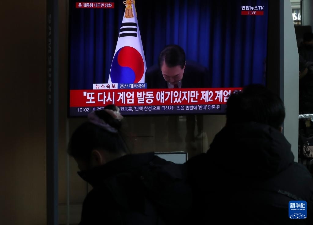 12月7日，在韓國首爾火車站，民眾觀看總統(tǒng)尹錫悅發(fā)表講話的電視畫面。新華社記者 姚琪琳 攝