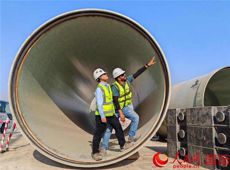 工作人員在察看輸水管情況。人民網(wǎng)記者 管克江攝