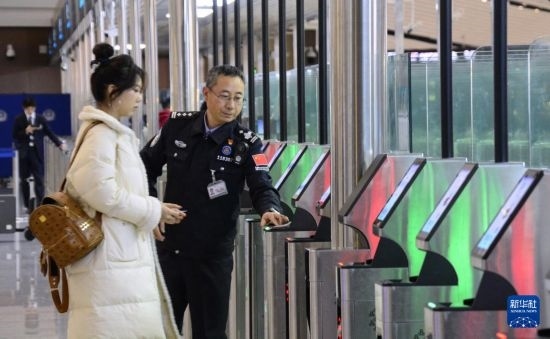 1月2日，大興機場邊檢站警察指導旅客使用自助出境設備。新華社記者 李欣 攝