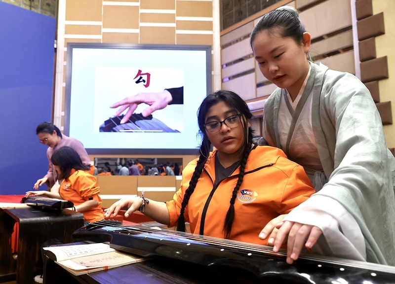 2024年3月20日，美國(guó)華盛頓州中學(xué)生代表團(tuán)北京大學(xué)交流活動(dòng)在北京大學(xué)英杰交流中心舉行。圖為來(lái)自華盛頓州的中學(xué)生體驗(yàn)古琴。