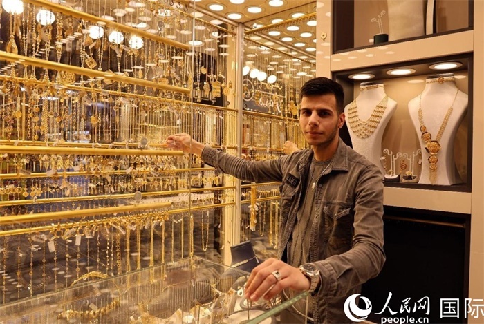 一名銷售員展示黃金飾品。人民網(wǎng) 伊納斯·易卜拉欣攝