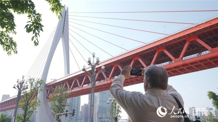 軻寶華“打卡”重慶東水門長江大橋。人民網(wǎng)記者 蘇纓翔攝