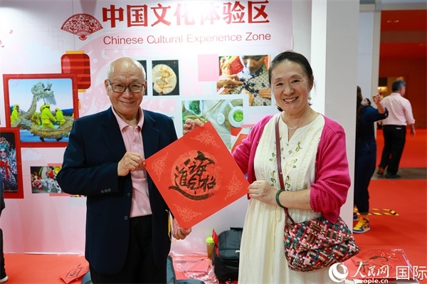 本地觀眾在中國文化體驗區(qū)展示書法作品。人民網(wǎng)記者 白元琪攝