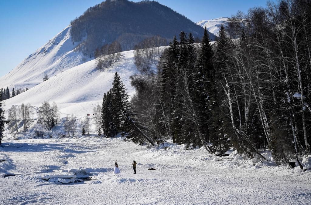 2024年2月5日，兩名游客在新疆阿勒泰地區(qū)布爾津縣禾木村拍照。新華社記者 馬鍇 攝