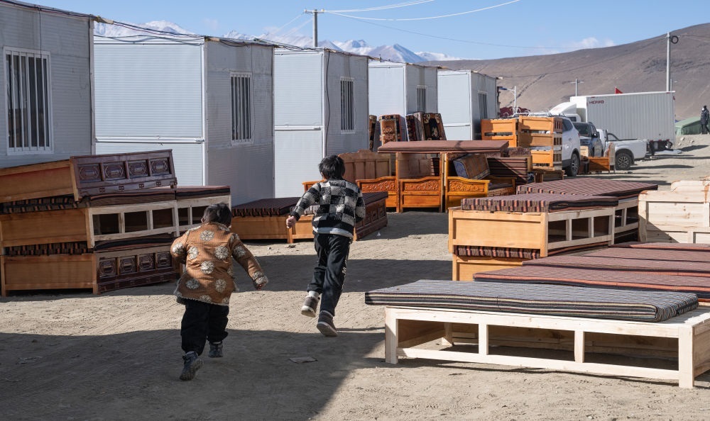 2025年1月13日，在定日縣嘎旦村，兩個孩子在剛運來的兩排藏床間奔跑。新華社記者丁增尼達 攝