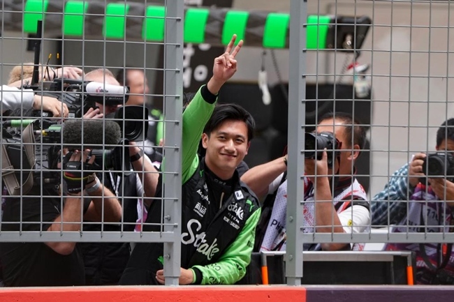 2024年4月19日，索伯車隊(duì)中國(guó)車手周冠宇（中）在練習(xí)賽前向觀眾致意。當(dāng)日，F(xiàn)1中國(guó)大獎(jiǎng)賽在上海開(kāi)賽。中國(guó)車手周冠宇主場(chǎng)首秀參賽。新華社記者 夏一方攝