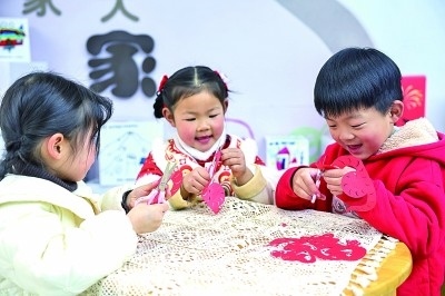 圖為孩子們?cè)诶蠋熤笇?dǎo)下制作蛇年主題剪紙。 新華社記者 徐昱攝