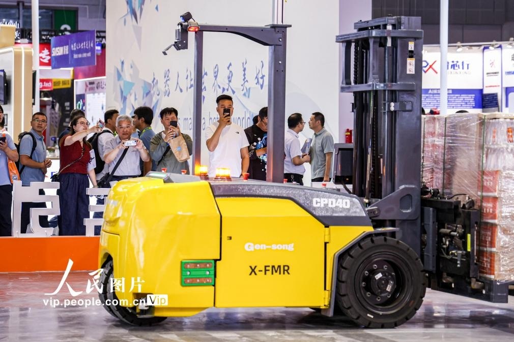 第24屆中國工博會現(xiàn)場，觀眾觀看叉取機(jī)器人作業(yè)演示。王初攝（人民圖片網(wǎng)）
