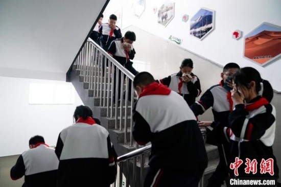  圖為學(xué)生們進行應(yīng)急疏散演練。中新社記者 趙宇航 攝