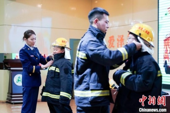 圖為學(xué)生們現(xiàn)場穿戴消防頭盔和戰(zhàn)斗服。中新社記者 趙宇航 攝
