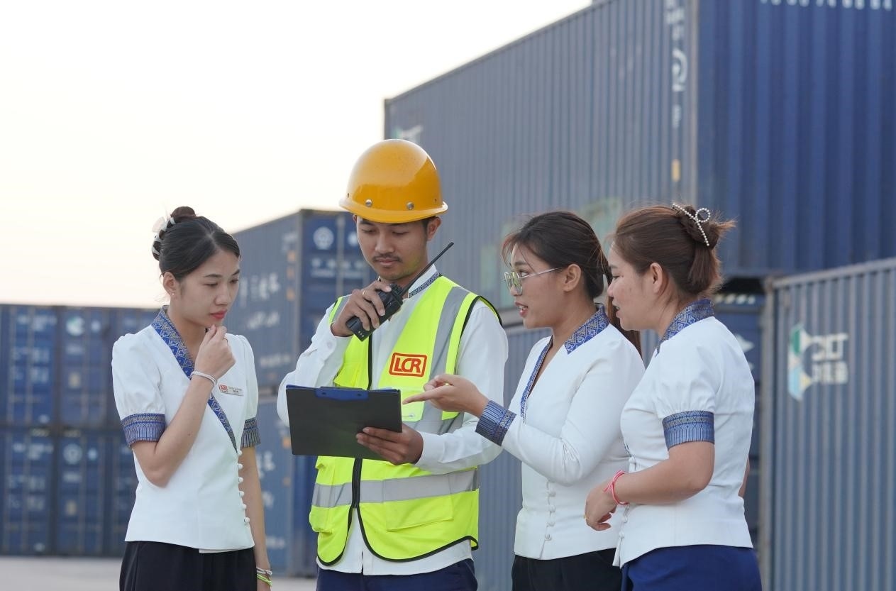 萬(wàn)象南站貨運(yùn)值班員陳尼啦（左一）與同事在一起討論工作。老中鐵路有限公司供圖