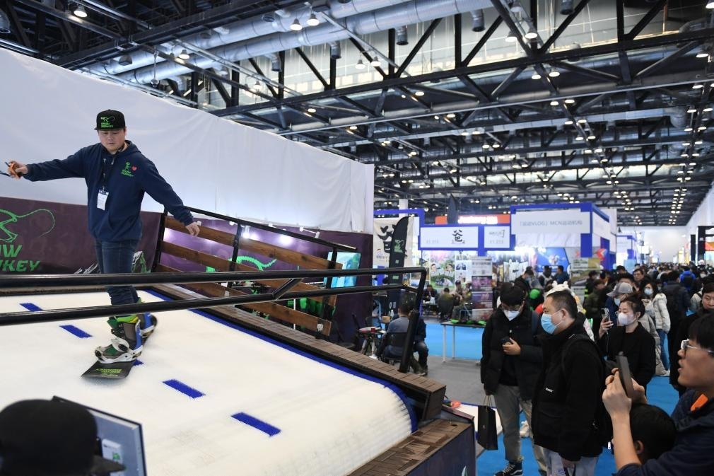 2023年2月11日，參觀者在展會(huì)上了解一款模擬滑雪設(shè)備。當(dāng)日，2023亞洲運(yùn)動(dòng)用品與時(shí)尚展在國(guó)家會(huì)議中心拉開(kāi)帷幕。新華社記者 張晨霖 攝