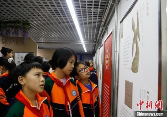 圖為學生參觀青海省博物館“1+3”主題流動展覽，了解木舞俑。中新社記者 馬銘言 攝