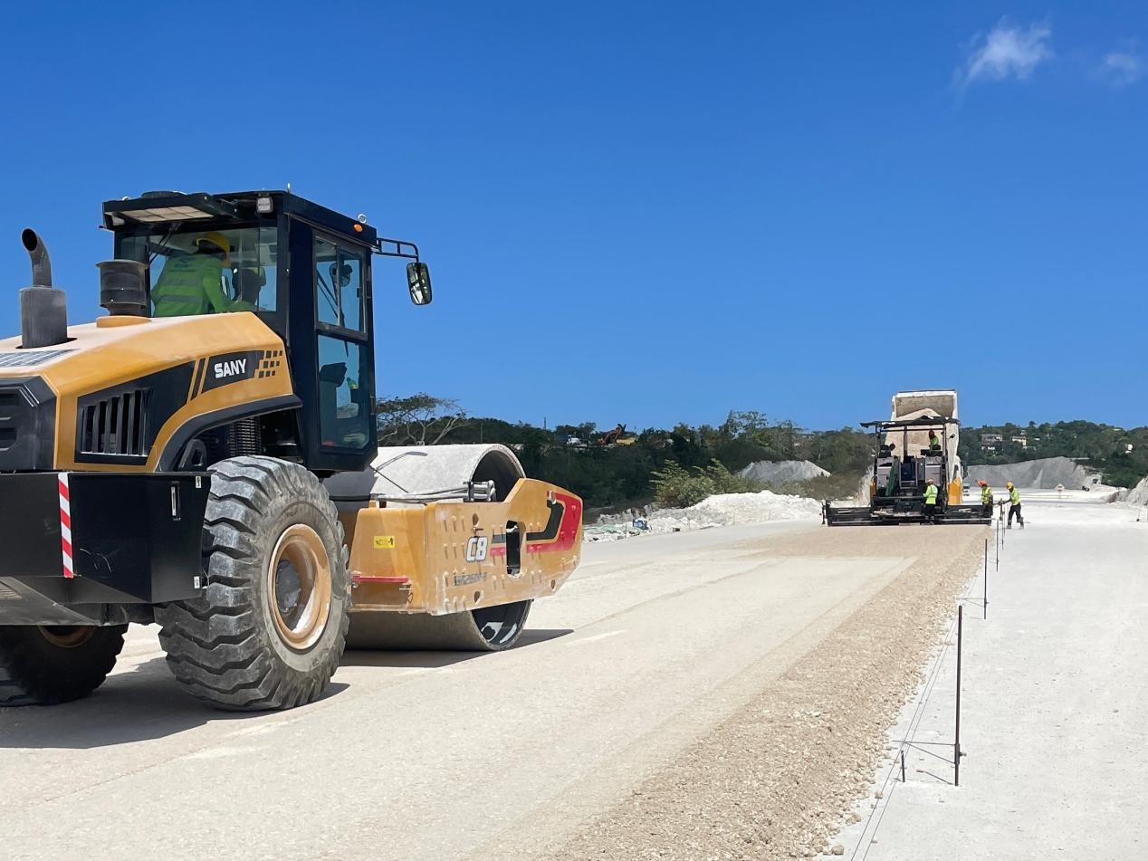 圖為中企承建的牙買加蒙特哥貝繞城路項(xiàng)目基層試驗(yàn)段正在進(jìn)行攤鋪和碾壓施工，相關(guān)施工工作已于日前順利完成。中國港灣美洲區(qū)域公司供圖