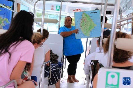 3月15日，一名導(dǎo)游在游艇上為游客介紹塞舌爾拉迪格島。新華社記者 董江輝 攝