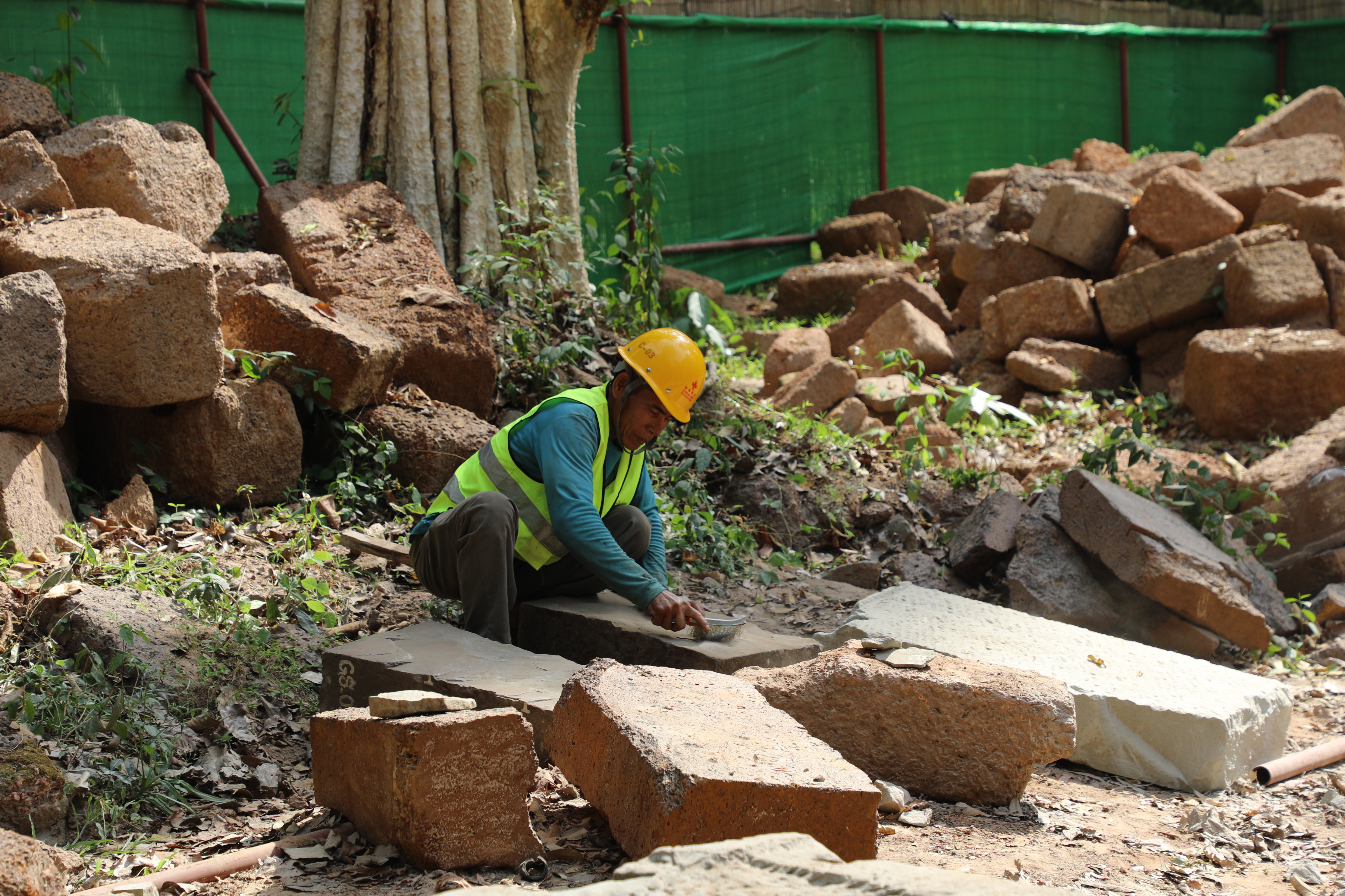 一名柬埔寨工人正在王宮遺址修復(fù)現(xiàn)場(chǎng)工作。（人民日?qǐng)?bào)記者曹師韻 攝）