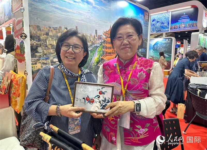 中國(guó)“大冶刺繡”傳承人劉小紅（右）參加泰國(guó)國(guó)際旅游展，向觀眾介紹中國(guó)非遺刺繡針法。人民網(wǎng)記者 簡(jiǎn)承淵攝