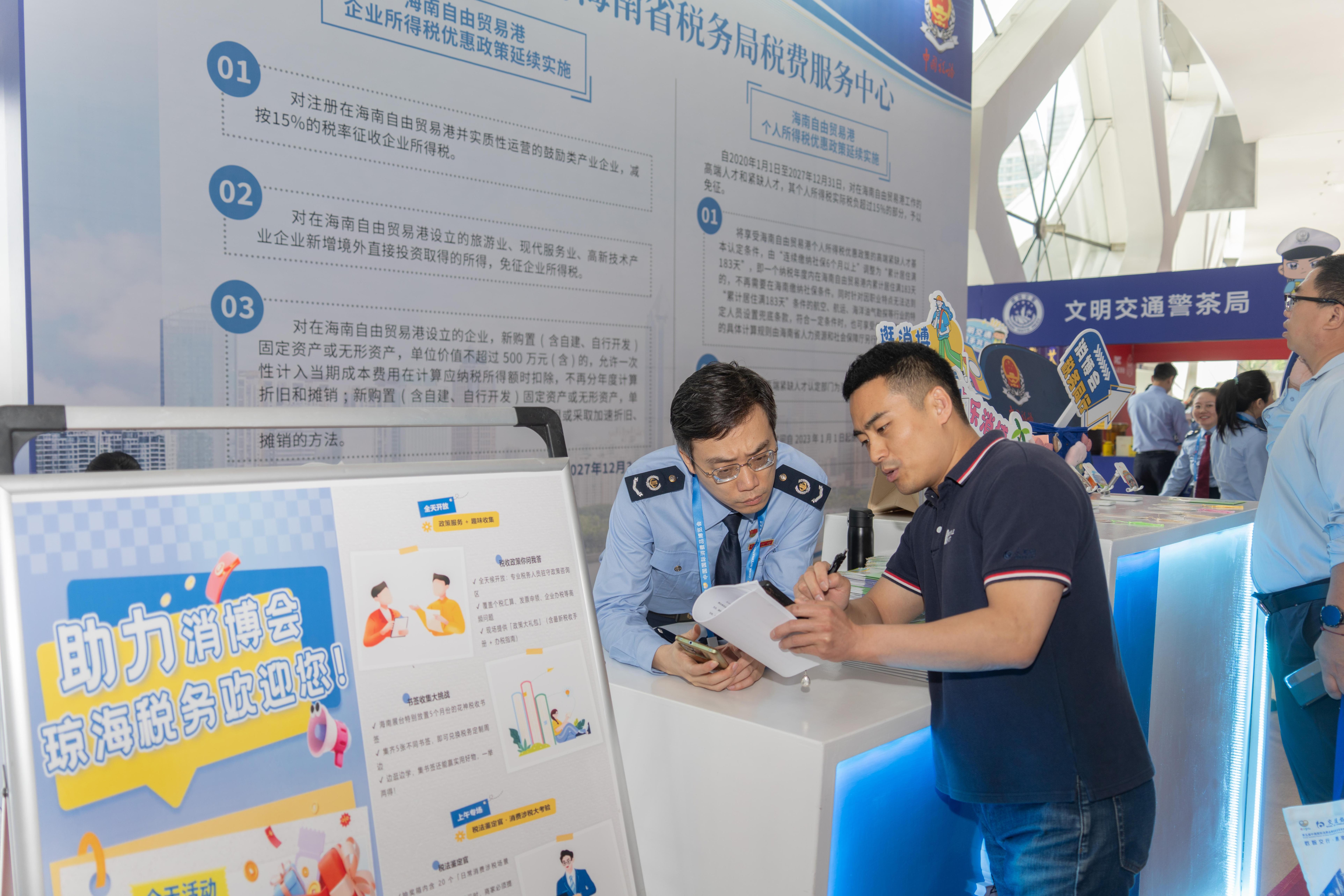 稅務(wù)服務(wù)臺工作人員向記者介紹服務(wù)參展外商的具體舉措。人民網(wǎng)記者 許崢攝