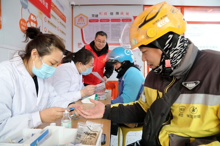 2025年3月5日，志愿者在山東省棗莊市市中區(qū)一工會(huì)驛站為外賣員免費(fèi)測(cè)量血糖。新華社發(fā)（王海楠攝）