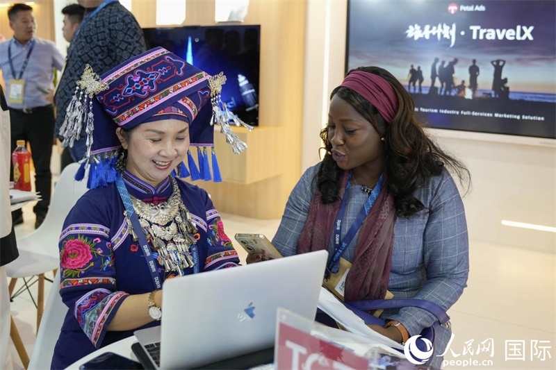 來自廣西的旅游業(yè)者同客戶交流。人民網(wǎng)塔里克·易卜拉欣攝