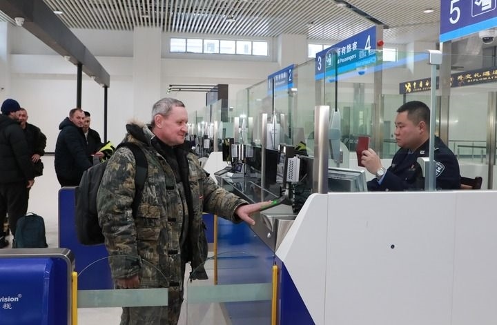 2024年12月10日，在黑河公路口岸旅檢大廳，黑河出入境邊防檢查站民警為首班次客車入境旅客辦理邊檢通關(guān)手續(xù)。當(dāng)日，中國黑河公路口岸—俄羅斯卡尼庫爾干公路口岸旅客運(yùn)輸正式開通。新華社發(fā)（劉松攝）