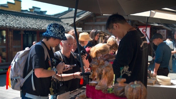 “五一”期間，游客正在烏鎮(zhèn)“水鄉(xiāng)碼頭”挑選購買文創(chuàng)產(chǎn)品。受訪者供圖