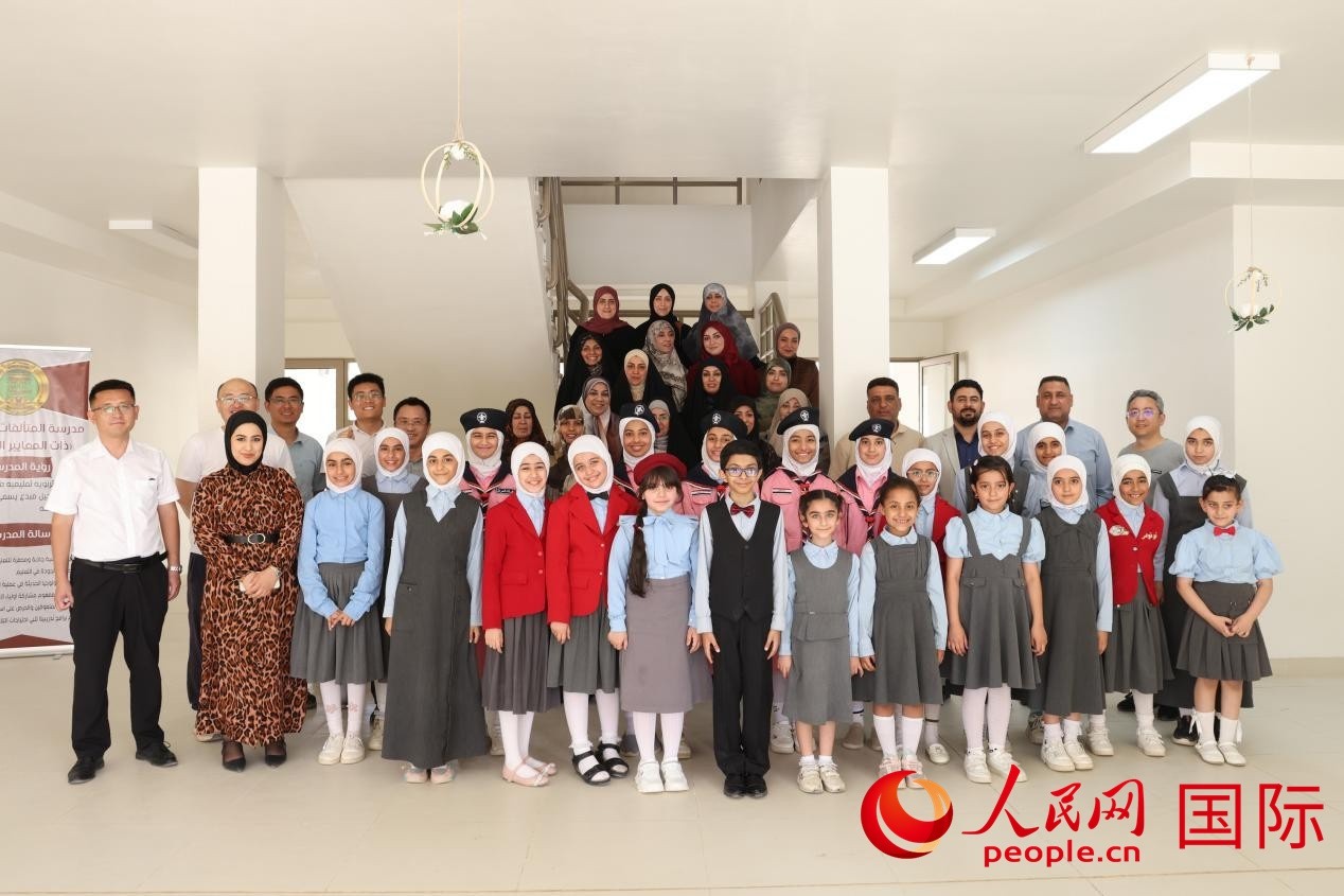 中國(guó)電建員工與阿爾穆塔?阿里卡特國(guó)際學(xué)校的師生及政府官員等合影。人民網(wǎng)記者 薛丹攝
