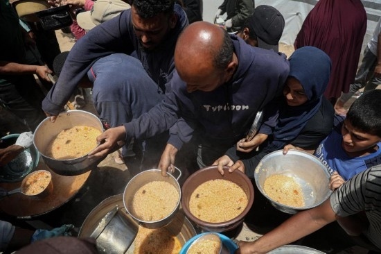 5月28日，人們在加沙城西部的沙提難民營領(lǐng)取救助食物。新華社發(fā)（里澤克·阿卜杜勒賈瓦德攝）