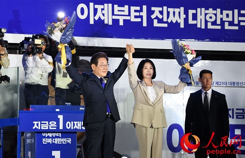 6月4日凌晨，確定當(dāng)選韓國總統(tǒng)的李在明舉手向歡呼的支持者們致意。 人民網(wǎng) 康炯彬攝